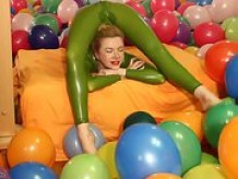 Contortionist blonde plays with balloons